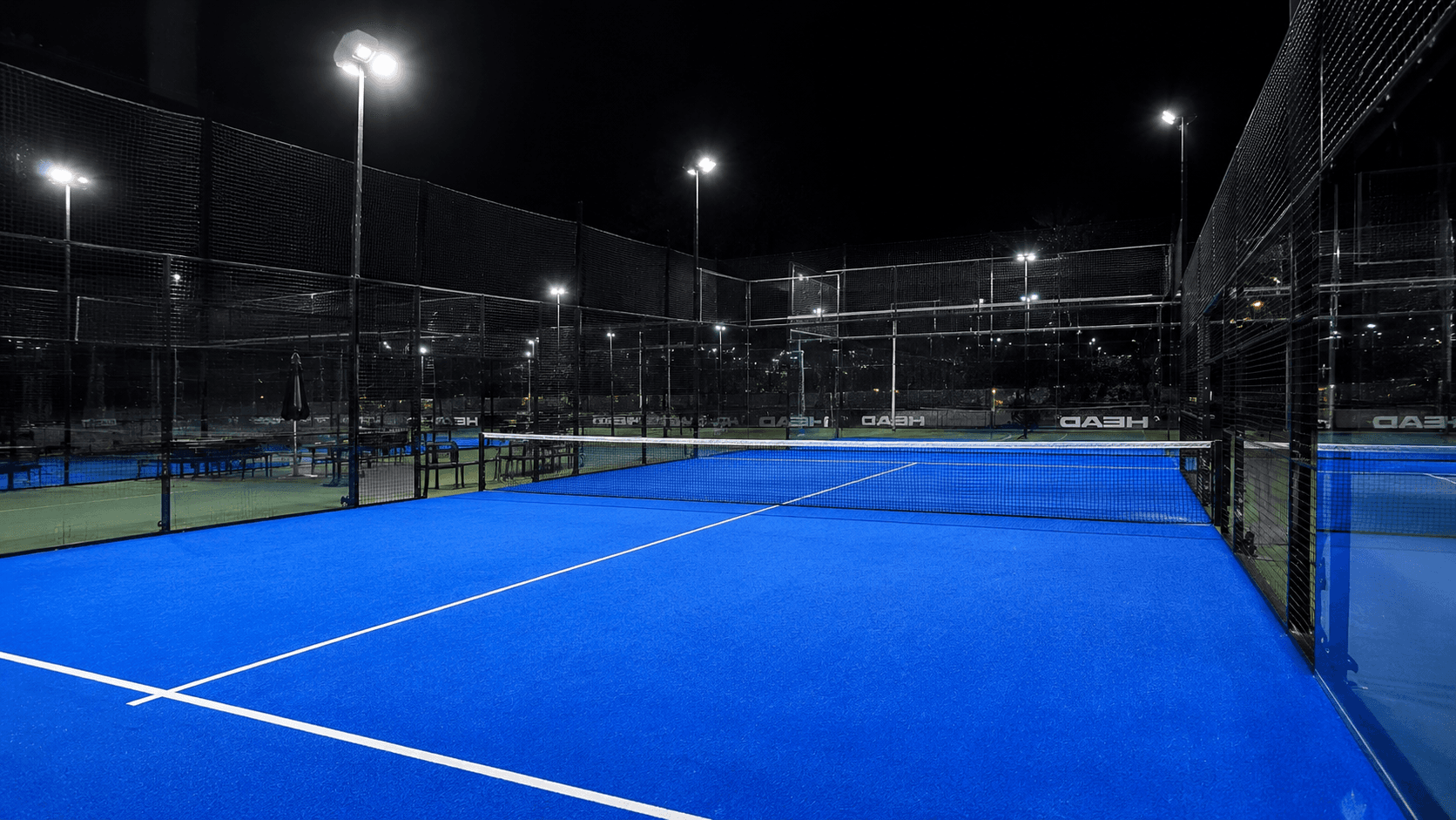 Cancha de pádel de noche con reflectores